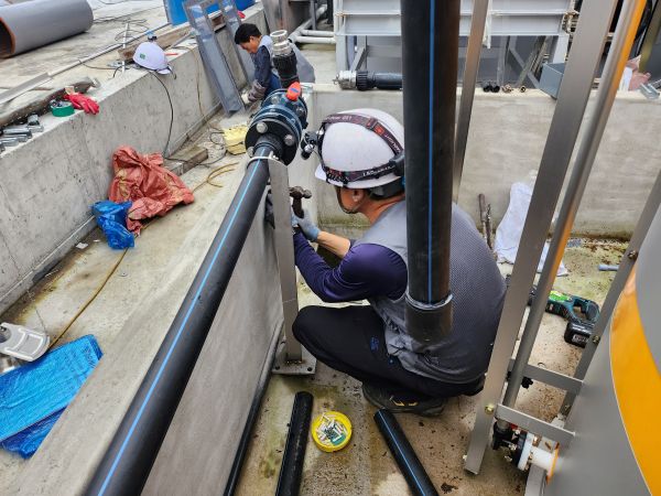 Installation work for a leak detector beneath a caustic soda tank at a Jeju aquaculture site